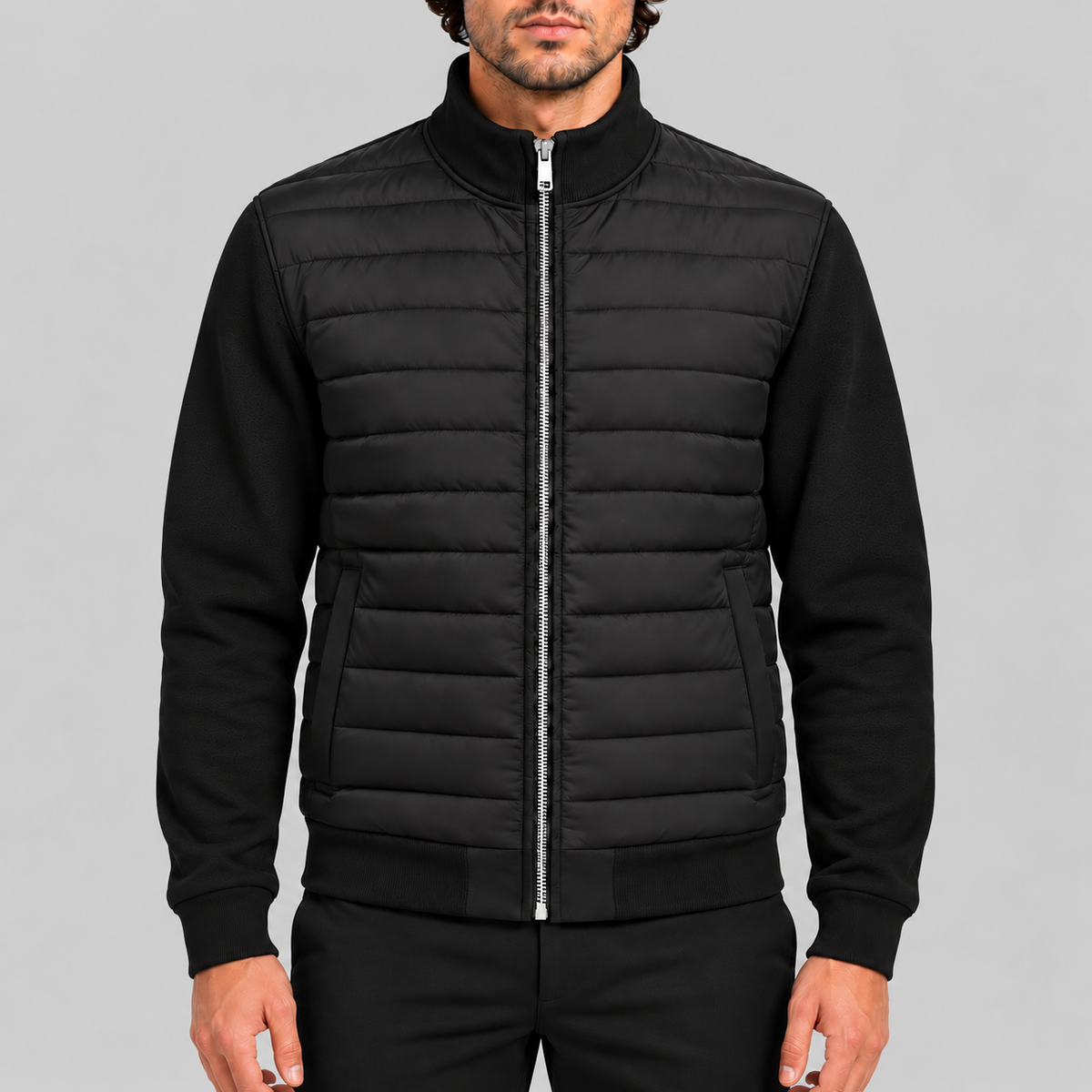 Men's hybrid quilted jacket with knitted sleeves in black, zipped up, front view